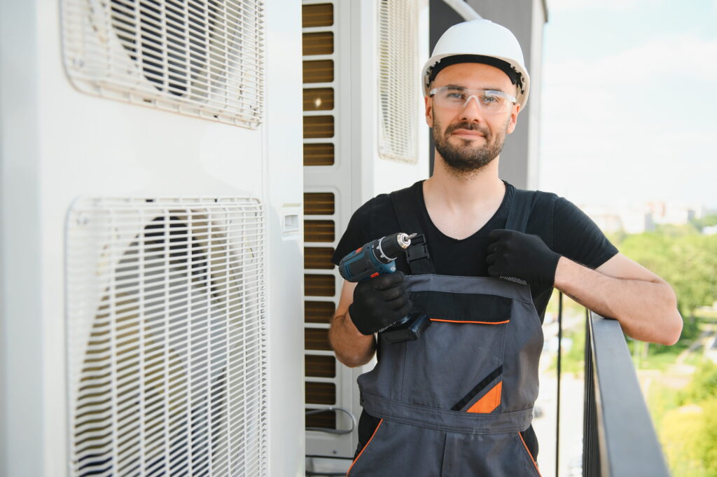 construction-worker-with-drill-near-air-condition - av plus services