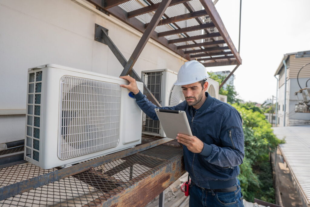technician-inspecting-air-conditioning - HVAC Repairs
